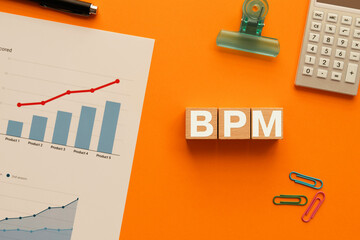 There is wood cube with the word BPM. It is an abbreviation for Business Process Management as...
