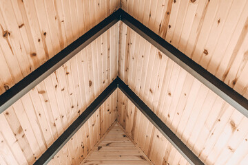 View of the top of a ceiling in a triangular shape made of wood