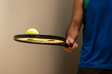 Man holding tennis racket with tennis ball