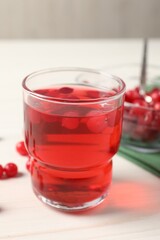 Tasty cranberry juice in glass and fresh berries on white wooden table, closeup