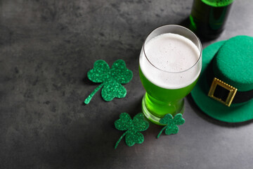 St. Patrick's day celebration. Green beer, leprechaun hat and decorative clover leaves on grey...