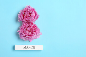 International Women's day. 8th of March made with beautiful peonies on light blue background, top view. Space for text