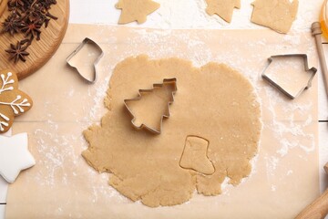 Making Christmas cookies. Raw dough, anise stars and cutters on white table, flat lay