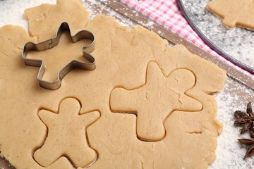 Making Christmas cookies. Raw dough and cutter on table