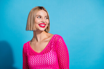 Photo portrait of lovely young lady look interested empty space dressed stylish pink knitwear garment isolated on blue color background