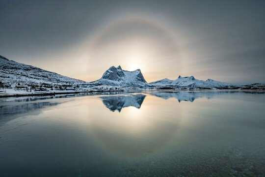 Sun ring, halo over snowy mountain range Kulhornet, arctic winter landscape, Kobbenestinden, in front sea, Ballangen, Nordland, Norway, Europe