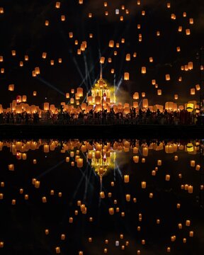 Yi Peng Festival with rising lanterns and a reflection in the lake, Chiang Mai, Thailand, Asia