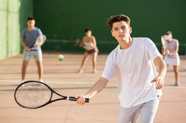 Young man playing frontenis on outdoor pelota court during training. Man playing Basque pelota speciality.