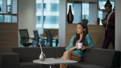 Serious woman relaxing sofa at lounge zone. Pensive asian lady resting couch