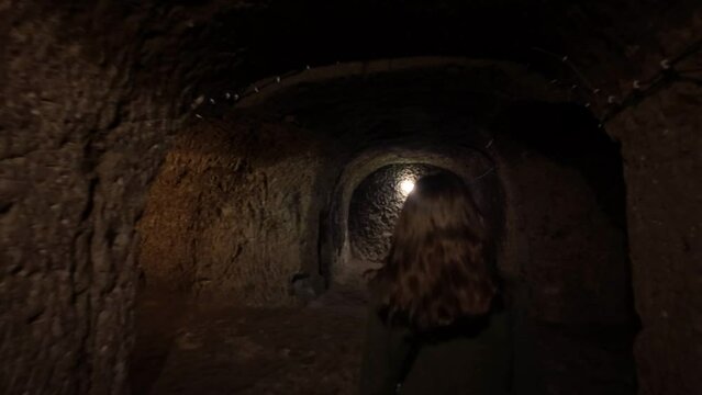 A woman walks in narrow tunnels of the Derinkuyu underground city built in BC 1200 in Cappadocia, Turkey.