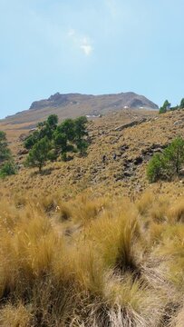 A man with a backpack takes an exciting trek to the top of a mountain, representing the pursuit of goals and personal achievement.