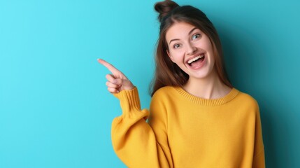 Fototapeta premium oung woman isolated on blue background pointing to a copy space, expressing excitement and desire