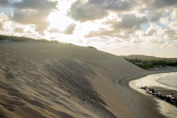 Fototapeta na wymiar postcard of sand dunes on a beach shore at sunset