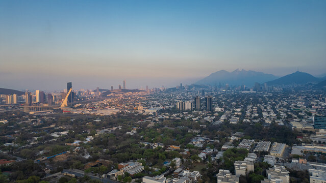 Vista panorámica desde arriba con el drone de la ciudad de Monterrey Nuevo León con el cerro de la silla de fondo lleno de edificios y casas poblado ciudad urbana