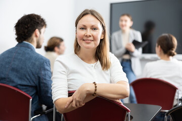 Diligent adult woman attending lecture in university