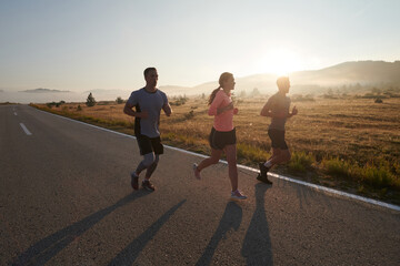 A group of friends, athletes, and joggers embrace the early morning hours as they run through the...