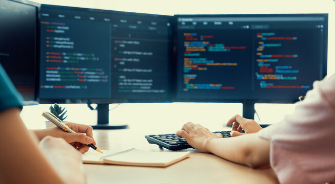 Female programer taking a note while young skilled web developer present program while computer displayed program code at modern office company. Java script, web design concept. Burgeoning.