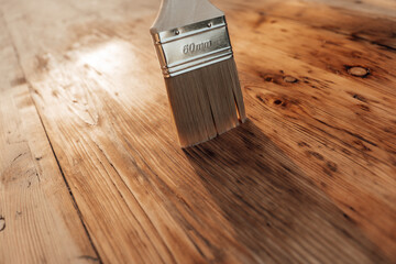 Brush on the wooden surface.Painting and oiling wooden surfaces.Oil and varnish for wood....