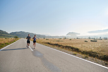 Energized by the beauty of nature, a couple powers through their morning run, their bodies and...