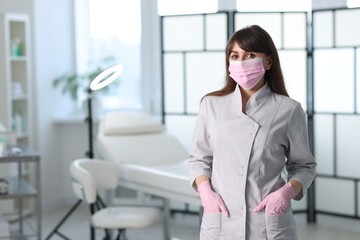 Cosmetologist in medical uniform in clinic, space for text