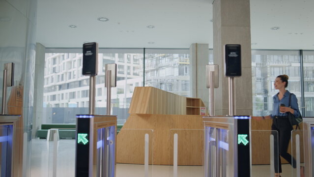 Woman unlocking electronic gates by modern smartwatch going to office work. - Powered by Adobe