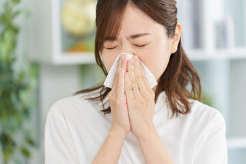 鼻炎で鼻をかむ女性
