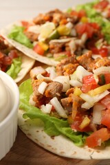 Delicious tacos with vegetables and meat on table, closeup