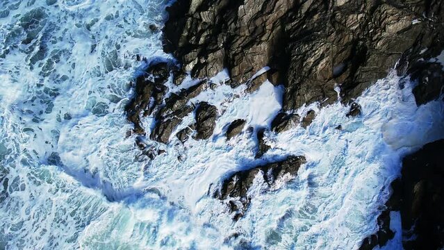 Ocean Waves in Slow Motion Crashing Over Cornish Rocks with Top Down View Overhead.