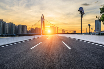 Asphalt road and bridge with modern city buildings at sunrise in Guangzhou