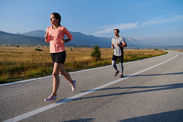 Energized by the beauty of nature, a couple powers through their morning run, their bodies and...