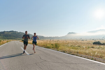 Energized by the beauty of nature, a couple powers through their morning run, their bodies and...