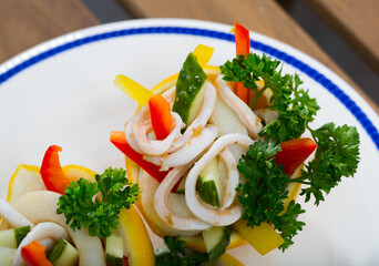 Tropical salad with calamari, cucumbers, red bell pepper, served in lemon halves with olive oil and greek yogurt