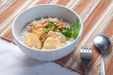 Bubur Ayam Sukabumi contains white rice porridge with side dishes of fried chicken slices