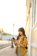 Traveler asian woman in her 30s using smartphone for navigation destination on the urban street at Bangkok, Thailand.