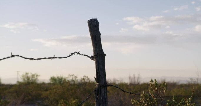 Rack focus from fence post to sky in background, sometime at dawn