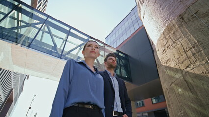 Couple business people posing at modern financial downtown in formal clothes. 