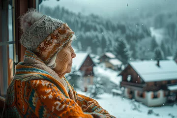 Foto auf Acrylglas Heringsdorf, Deutschland Thoughtful grandmother in knitwear looking out from her warm homely kitchen to a serene snowcovered village tranquility amidst winter