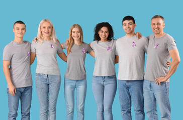 Obraz premium People with lavender awareness ribbons hugging on blue background. World Cancer Day