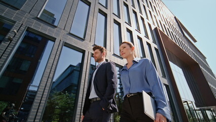 Confident company partners walking urban street. Two colleagues going at work
