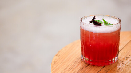 Red Cocktail with mint and ice on the wooden table, selective focus.