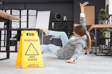 Traumatized young businesswoman fell down on wet floor in office