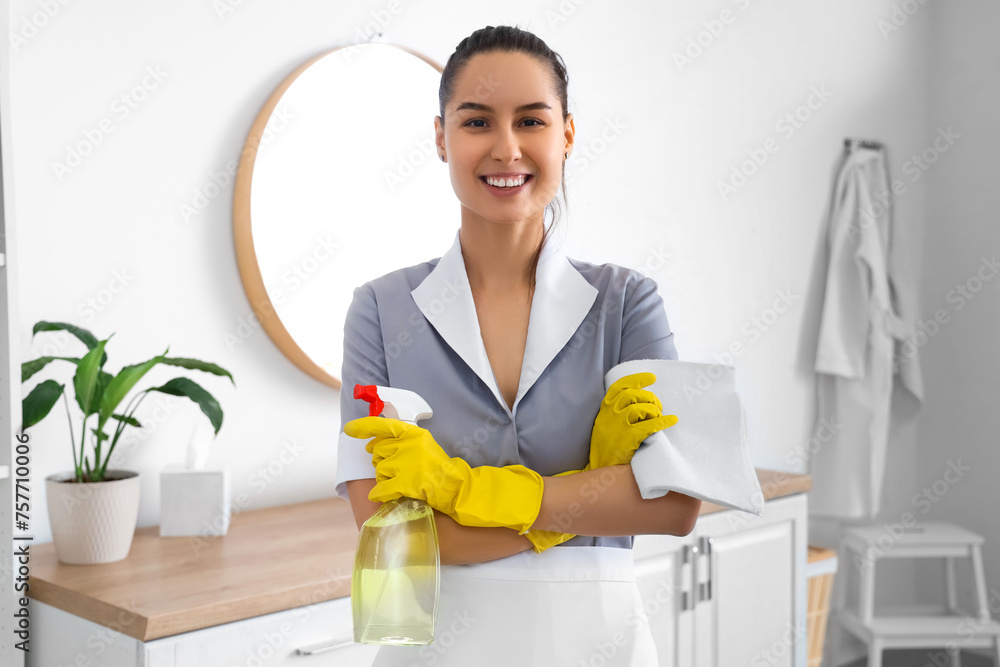 Canvas Prints Young chambermaid with detergent and rag in bathroom