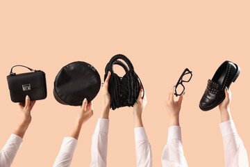 Female hands with stylish women's bags and different accessories on beige background