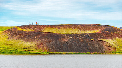 Skutustadagigar pseudo craters of volcanoes at Myvatn lake in Iceland, with tourists walking on craters rim