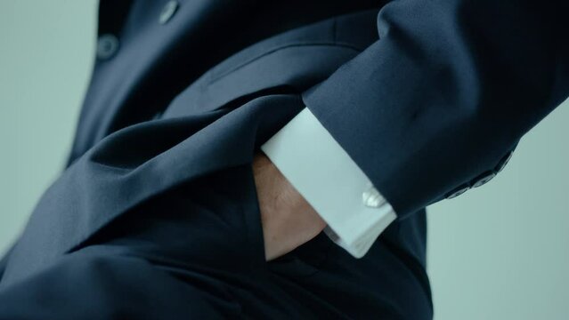 Close up of elegant man in suit putting his hand in pocket