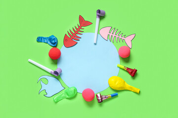 Blank card with paper fishes and party decor on green background. April Fools Day celebration