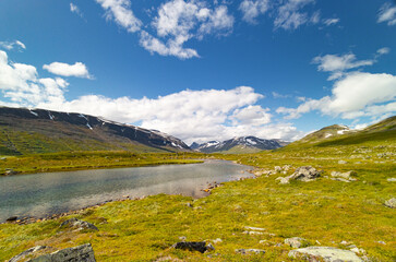 A beautiful small mountain lake in Sarek National Park, Sweden during august. Summer landscape of northern wilderness in Scandinavia.