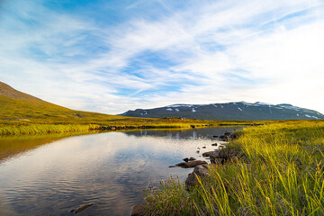 A beautiful small mountain lake in Sarek National Park, Sweden during august. Summer landscape of northern wilderness in Scandinavia.