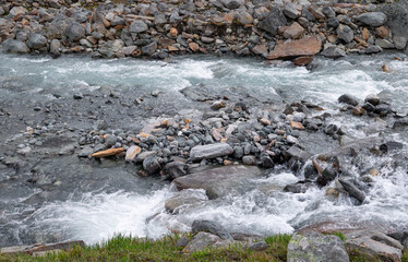A wild, turbulent mountain river in the Sarek National Park, Sweden. A summer scenery with water in Northern Europe.