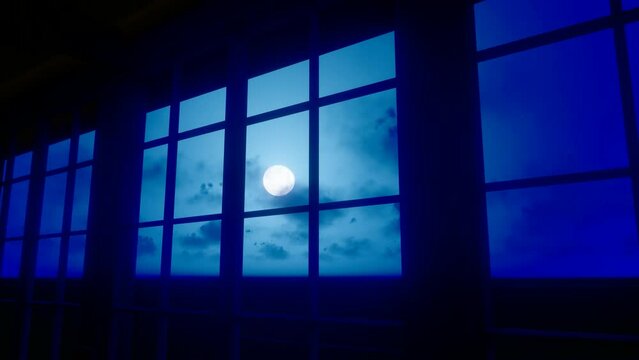 The moon rises outside the window